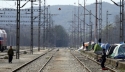 Mali migranci graj w pik na torach kolejowych na granicy grecko-macedoskiej. (Fot. EPA/Armando Babani)